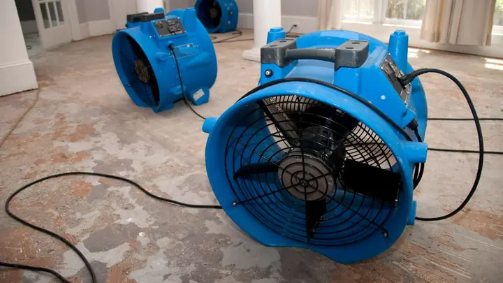 Blue air mover drying a concrete floor