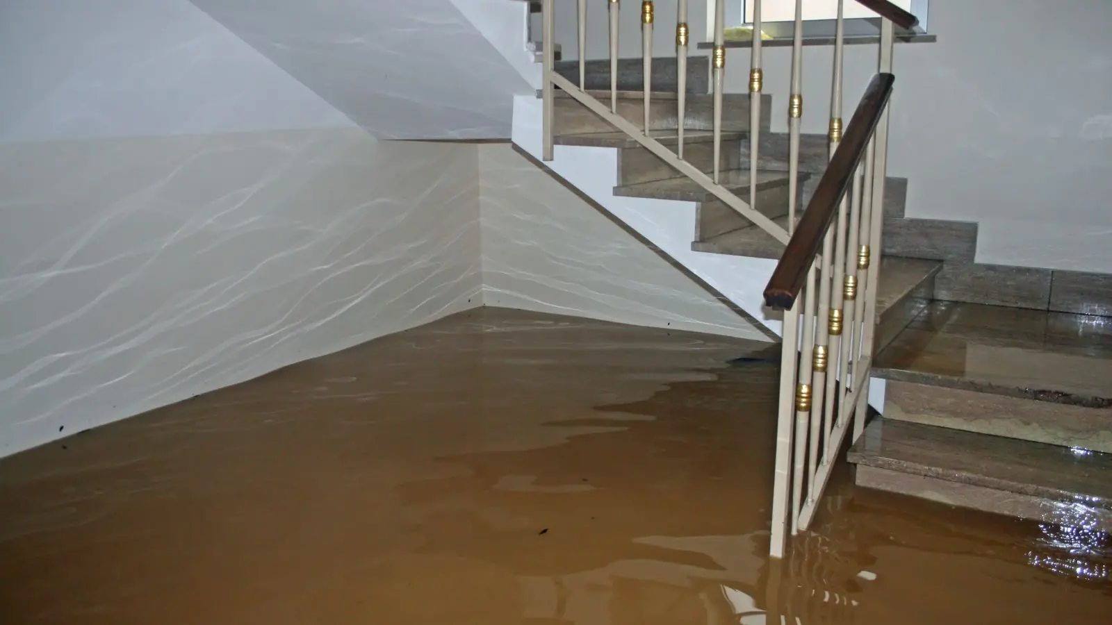 Flooded basement stairway with water covering the floor